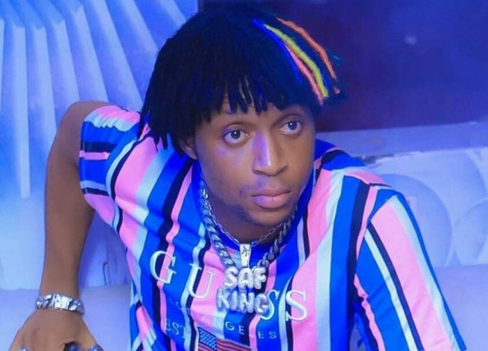 chateur noir ivoirien avec des cheveux coloré assis dans une discothèque